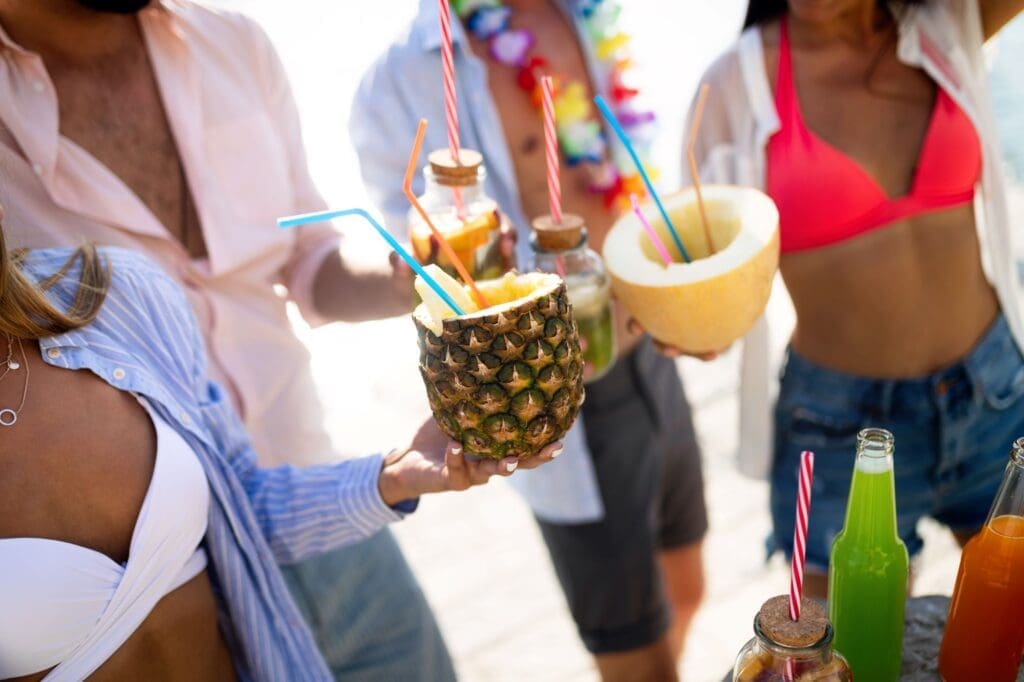 young group of friends enjoying drinks on the beach
